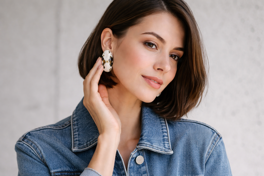 Modern woman wearing durable white porcelain statement earrings with a denim jacket.