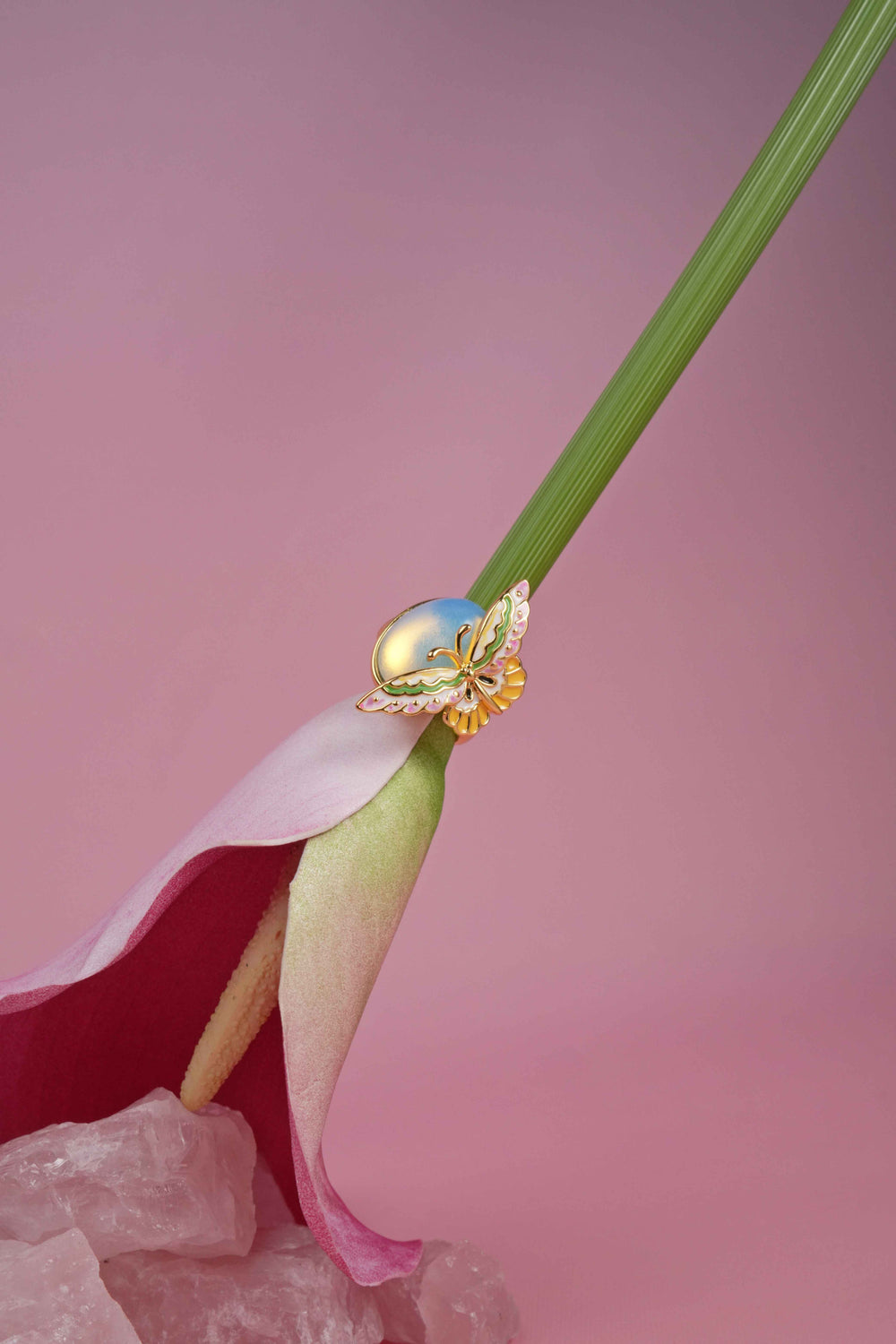 Gold handmade Butterfly-shaped Moonstone Enamel adjustable ring on a pink background.