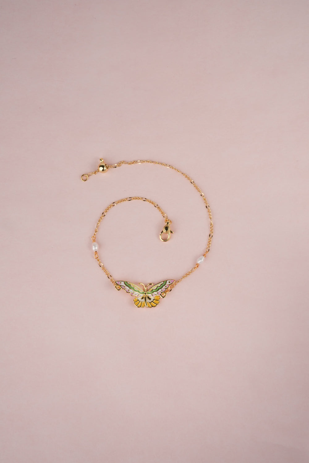 gold Enamel Butterfly Pearl Bracelet on the pink background.
